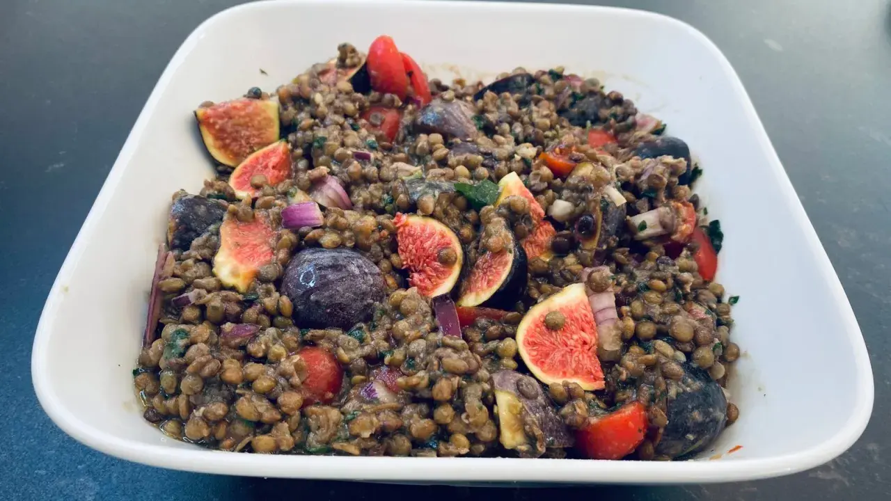 Salade de lentilles aux figues, tomates cerises, olives et oignons rouges. Un plat coloré et savoureux.