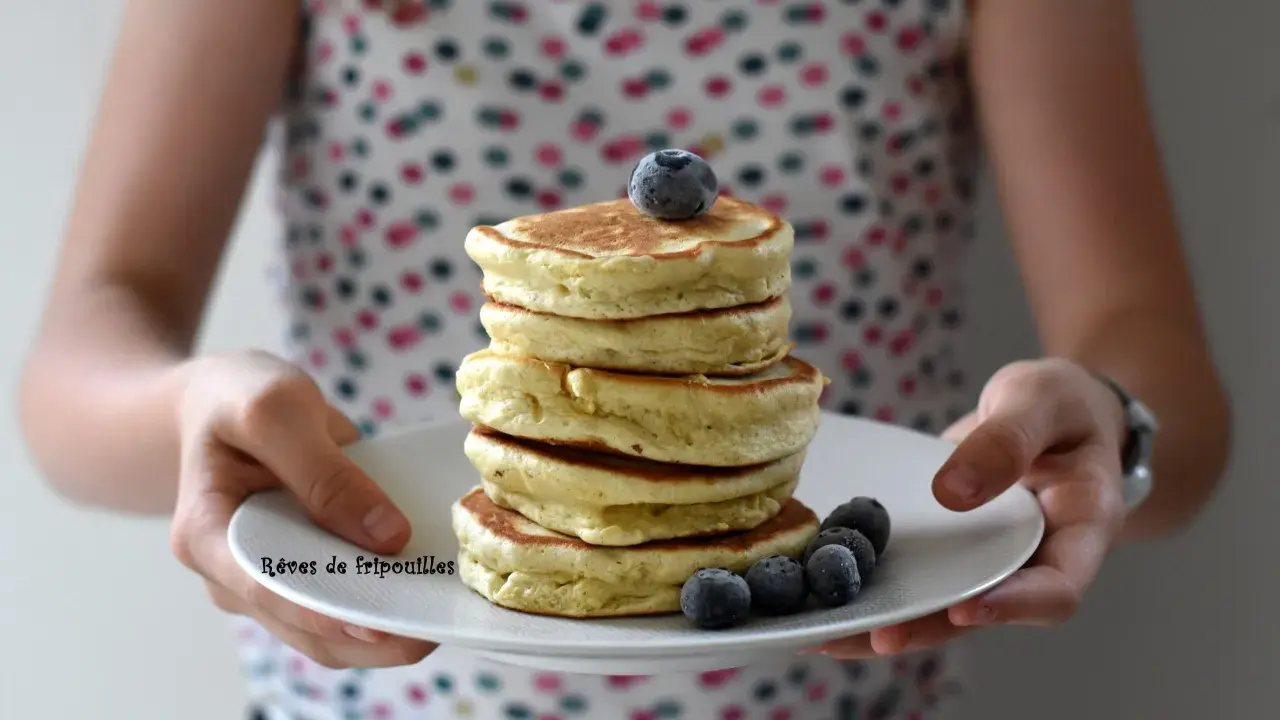 Pile de pancakes moelleux, parfaits pour une recette facile et gourmande, décorés de myrtilles fraîches.