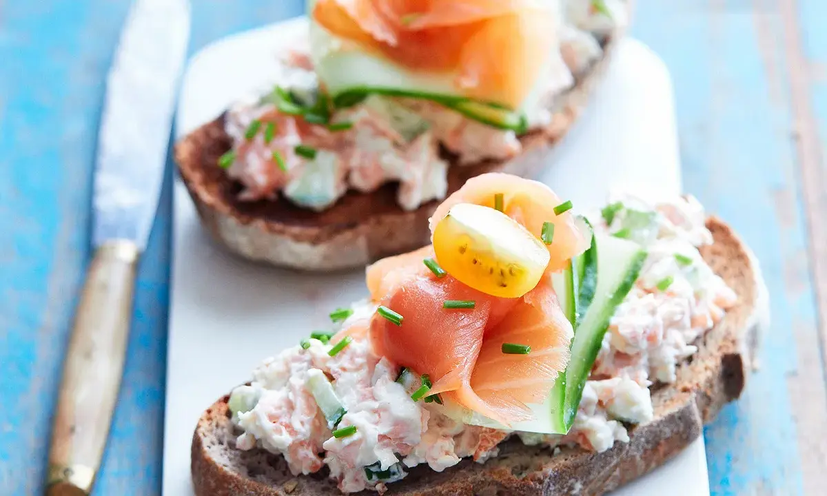 Tartines de rillettes de saumon, garnies de concombre, tomate cerise et ciboulette. Un délice frais et coloré.