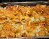 Un gratin dauphinois doré et croustillant, prêt à être dégusté. Les fines tranches de pommes de terre sont nappées d'une sauce crémeuse et gratinées à la perfection.