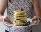 Pile de pancakes moelleux, parfaits pour une recette facile et gourmande, décorés de myrtilles fraîches.