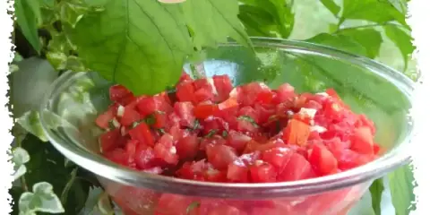 Salade tomate basilic fraîchement préparée, prête à être dégustée. Un délice simple et savoureux.