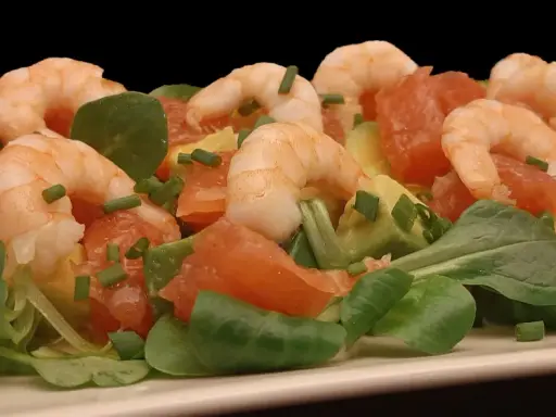 Salade fraîche et colorée : crevettes, avocat, pamplemousse rose, roquette et ciboulette. Un délice léger et savoureux.