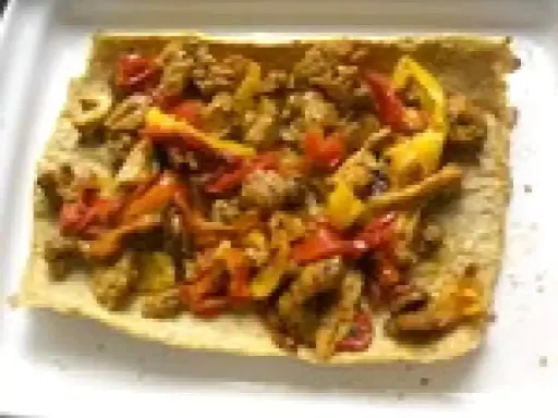 Un wrap poulet poivron, garni de morceaux de poulet et de poivrons colorés, prêt à être dégusté.