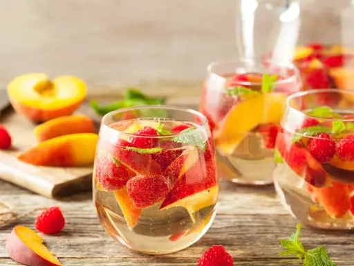 Délicieuse sangria blanche recette avec pêches, framboises et menthe fraîche. Parfait pour se rafraîchir !