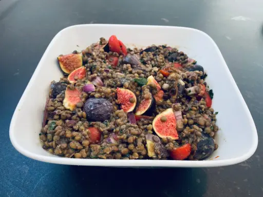 Salade de lentilles aux figues, tomates cerises, olives et oignons rouges. Un plat coloré et savoureux.