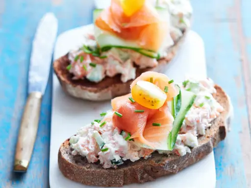 Tartines de rillettes de saumon, garnies de concombre, tomate cerise et ciboulette. Un délice frais et coloré.