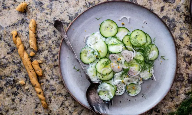 Salade de concombre crémeuse, parfaite pour une recette légère. Des rondelles fines de concombre, oignon rouge, aneth frais et une sauce onctueuse.