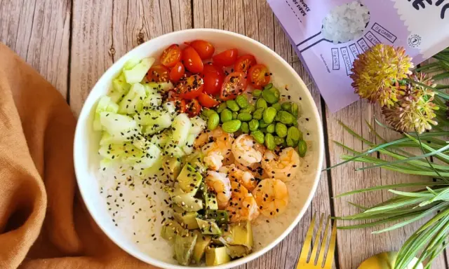 Délicieuse recette salade asiatique : riz, crevettes, avocat, concombre, tomates cerises et edamame, parsemée de graines de sésame.