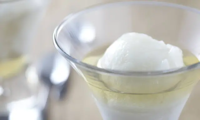 Une boule de sorbet citron dans un verre rempli de Calvados. Une recette de trou normand pour un dessert rafraîchissant.