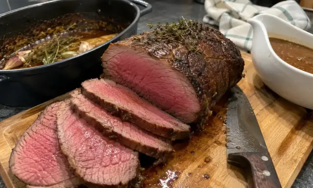 Un délicieux roti de boeuf cocotte, saignant et tendre, prêt à être dégusté avec sa sauce onctueuse.