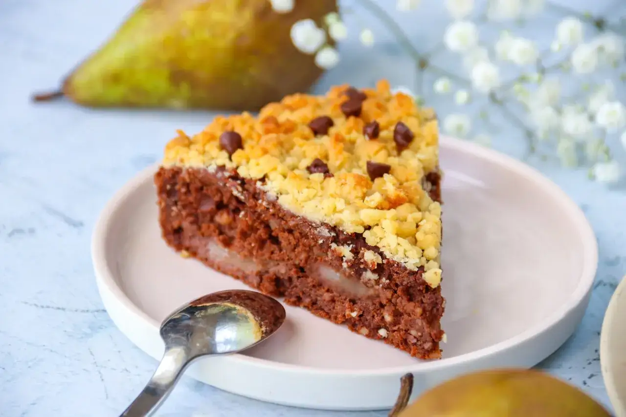 Tranche de crumble poire chocolat, avec des morceaux de poire fondants et un dessus croustillant parsemé de pépites de chocolat.