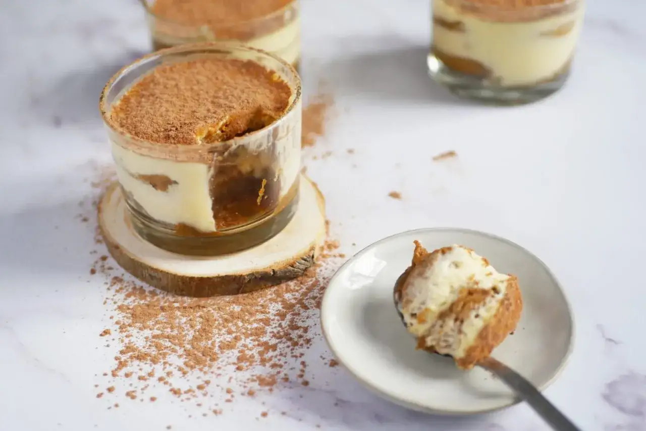 D&eacute;licieux tiramisu individuel, un dessert minute sans cuisson, saupoudr&eacute; de cacao. Une cuill&egrave;re en est pr&ecirc;te &agrave; &ecirc;tre d&eacute;gust&eacute;e.