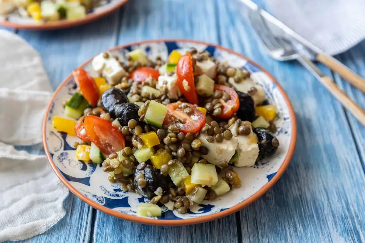 Salade de lentilles color&eacute;e avec tomates, concombre, poivrons, olives noires et feta. Un plat frais et savoureux.