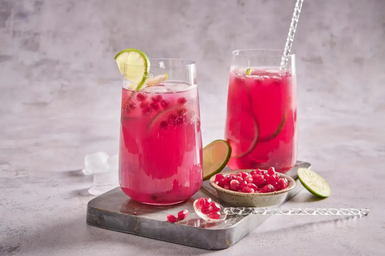 Cocktail rose vif, garni de rondelles de citron vert et de graines de grenade. Un d&eacute;lice rafra&icirc;chissant, ce cocktail fruit du dragon est pr&ecirc;t &agrave; &ecirc;tre d&eacute;gust&eacute;.